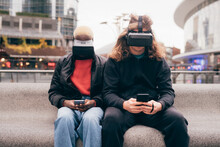 Italy, Couple With VR Goggles And Smart Phones In City
