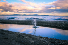 VANCOUVER ISLAND - A Splash In A Puddle In Front Of The Ocean During Sunset 