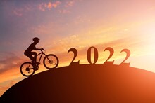Silhouette Of Cyclists With Bicycles At Sunset. New Year 2022. Holiday Concept.