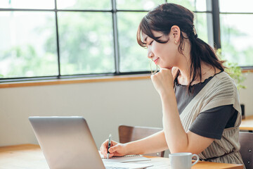 おしゃれ空間で勉強する女性（笑顔）
