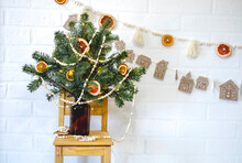 Brown Glass Jar With Fir Branches Stands On A Wooden Chair. Zero Waste Christmas Concept.