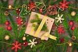 Fototapeta Sypialnia - Christmas gift with a bow among Christmas tree branches. New Year envelope