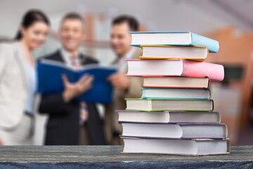 Poster - Hardcover law books stacked on wooden table on blur room background, Law Office, pile of books