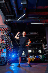 Wall Mural - Attractive adult man doing exercises and lifting weights in the gym. Sports training in the gym