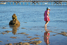 A Girl Wearing Casua Pink Dress S Walking Along The Sea Shore. Recreation Concept