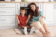 © Pixel-Shot - Little boy and his older sister eating tasty cookies in kitchen
