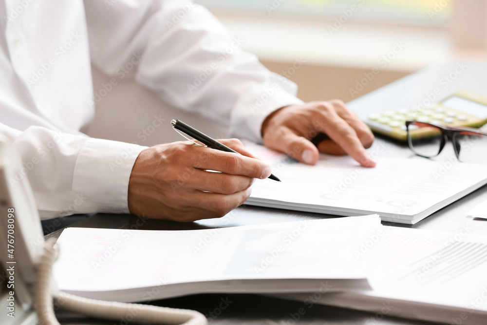 Businessman working with documents at desk in office, closeup