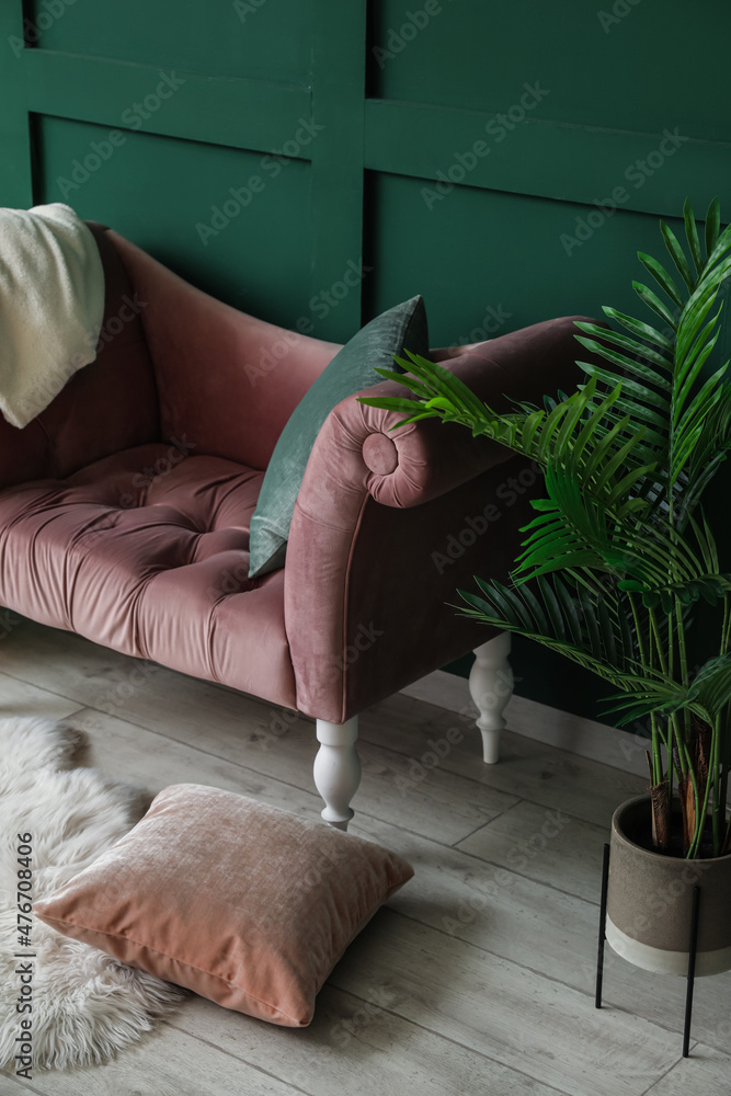 Modern interior with stylish couch near green wall