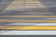 Yellow-white stripes on a pedestrian crossing as a background.