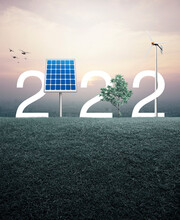 2022 White Text With Solar Cell, Wind Turbine And Growing Tree On Green Grass Field Over Aerial View Of Cityscape At Sunset, Vintage Style, Happy New Year 2022 Ecological Cover Concept