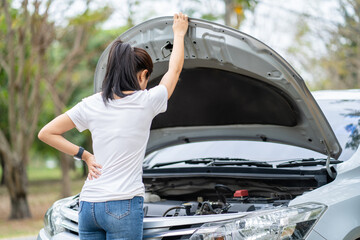 Wall Mural - Portrait of young woman standing in front of her broken car. Woman spection.