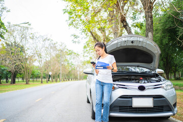 Wall Mural - Beautiful asian woman calling for assistance with his car broken down by the roadside.