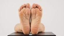 Asian Male Soles Of Feet And Barefoot Are Isolated On Chair With White Background.