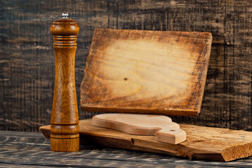 Cutting board and salt shaker on a black shabby table. Shred peppers on a dark background. Copy space and free space for extras near cooking tools. sharpness on the salt shaker.