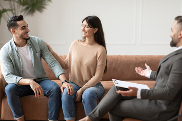 Wall Mural - Happy couple reconciling at therapy session in therapists office