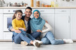 © Prostock-studio - Portrait Of Happy Islamic Family With Little Daughter Posing In Kitchen