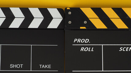 Two Black and yellow Clapper board or movie slate on yellow background.