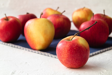 Ripe and sweet red apples on a blue napkin on a white background.