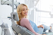 © Prostock-studio - Smiling and relaxed young woman sitting at dental chair