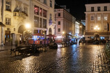 Fototapeta Na drzwi - Night rainy view to the Rynok or Market Square in Lviv, Ukraine. October 2021