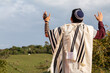 Horizontal photo of Juido Latino wearing tefilin and kippah raising his hands praying while looking at the sky with a beautiful background of natuleza.