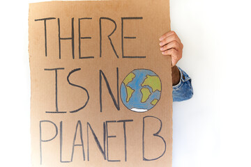 Close up of hand with denim jacket holding there is no planet b sign over white background