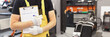 © megaflopp - Auto mechanic in workshop holds clipboard for taking orders closeup