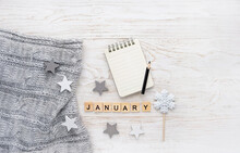 Knitted Sweater, Letter "january", Notepad, Pencil, Snowflake Candy On White Wooden Background. January Month Calendar Concept. Winter Season. Flat Lay. Copy Space