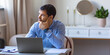 © Stavros - Pensive young man in front of laptop monitor in home interior.