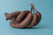 Bunch of black bananas aged on a blue background