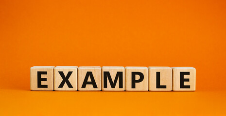 example symbol. the concept word example on wooden cubes. beautiful orange table, orange background,