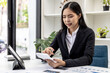© kamiphotos - Businesswoman using a white calculator, a financial businessman examining the numerical data on a company financial document, she uses a calculator to verify the accuracy of numbers.