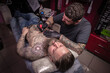 © Mr. Prof - Tattoo specialist demonstrates process of making a tattoo his salon