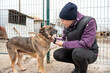 © andyborodaty - Girl volunteer in the nursery for dogs. Shelter for stray dogs.