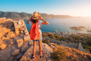 Sticker - Woman traveler explores the ruins of the castle of Simena with a view of the sea bay and Kekova Island with the famous flooded city. Tourist attractions in Turkey