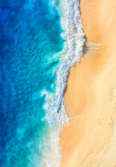 Wall Mural - beach and waves as a background from top view. blue water background from drone.