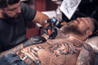© Mr. Prof - Master tattooist doing tattoo in tatoo salon