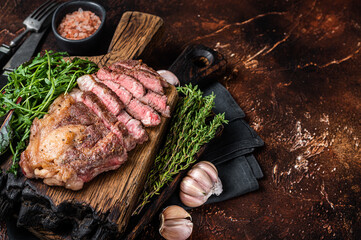 Wall Mural - Grilled Chuck Roll beef steak with salad on wooden board. Dark background. Top view. Copy space