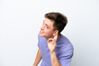 © luismolinero - Young handsome Brazilian man isolated on white background listening to something by putting hand on the ear