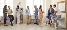 Groups Of Young And Mature People Standing In Modern Spacious Office After Big Business Event Or Company Corporate Meeting, Having Informal Discussions And Making Useful Contacts For Collaboration