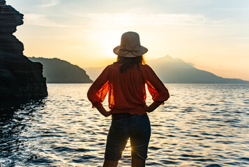 back view of young girl over sea sunset on Amalfi coast. Travel, relax, vacation