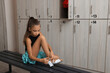 Little girl putting on shoes in locker room