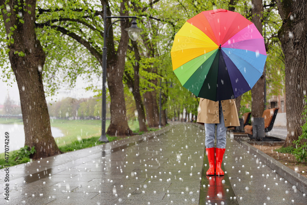 Young woman with umbrella walking in park on rainy day with hail Stock ...
