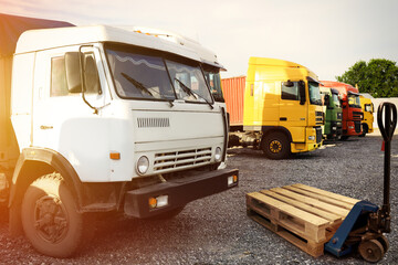 Wall Mural - Modern manual forklift with wooden pallets near trucks outdoors on sunny day