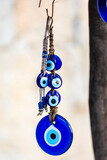 Fototapeta  - Blue evil eye, nazar boncugu, Turkish symbols hanging on a tree; Cappadocia