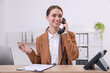 © New Africa - Female receptionist with clipboard talking on phone at workplace