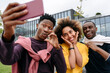 © Westend61 - Young man taking selfie with friends on mobile phone