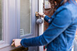 © Westend61 - Woman at entrance opening door lock with key