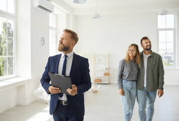 Wall Mural - Real estate agent giving future buyers or tenants tour about modern house. Boyfriend and girlfriend or husband and wife who consider property investment looking at new spacious home they might buy