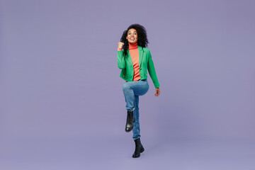 Canvas Print - Full size body length excited young black curly woman 20s wears casual clothes doing winner gesture celebrate clenching fists say yes isolated on plain pastel light violet background studio portrait.